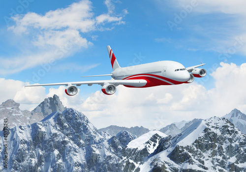 White passenger plane above the mountains