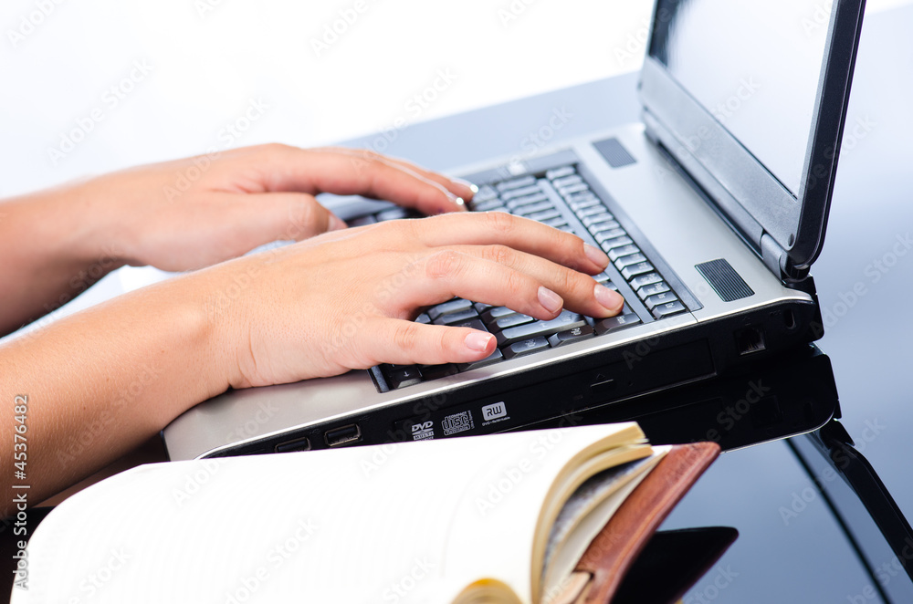 Woman's hands working on notebook keyboard Woman's hands working on notebook keyboard
