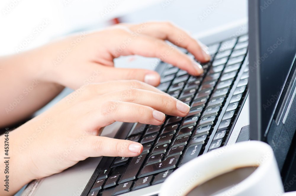 Woman's hands working on notebook keyboard Woman's hands working on notebook keyboard