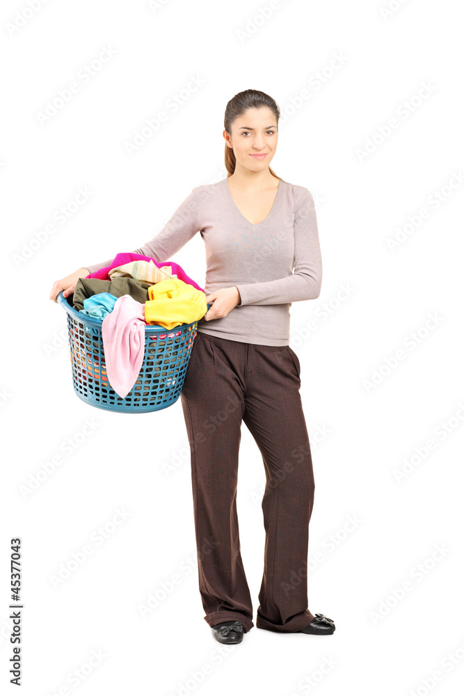 Full length portrait of a smiling female holding a laundry baske Full length portrait of a smiling female holding a laundry baske