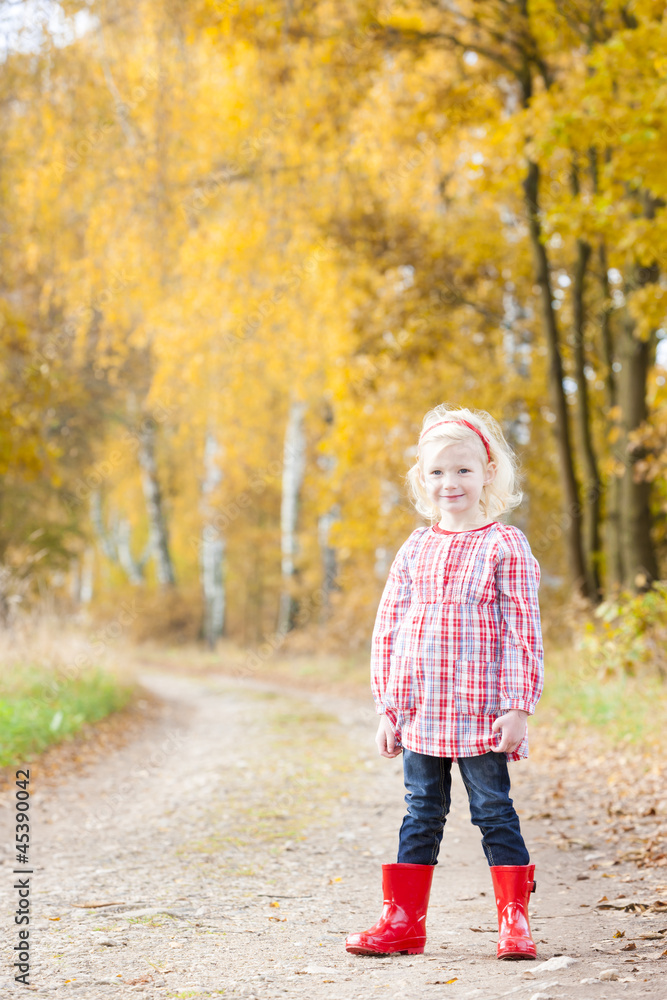 little girl wearing rubber boots in autumnal alley little girl wearing rubber boots in autumnal alley
