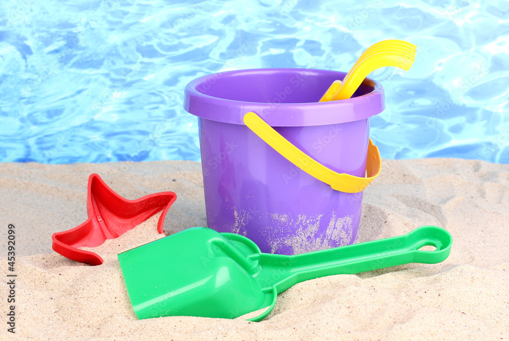 Children's beach toys on sand on water background Children's beach toys on sand on water background