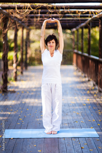 middle aged woman stretching outdoors