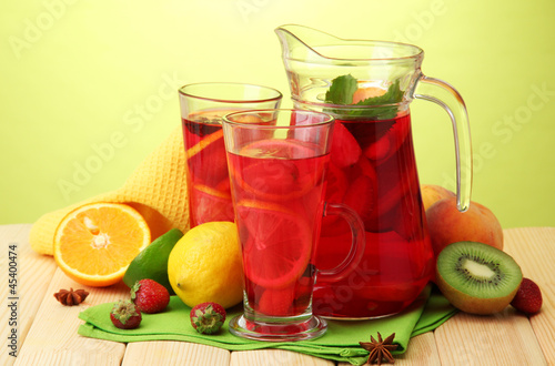 sangria in jar and glasses with fruits,