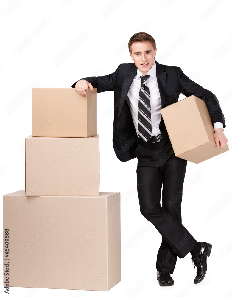 Manager in suit stands near pile of cardboard boxes Manager in suit stands near pile of cardboard boxes