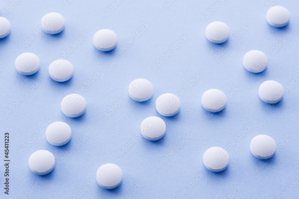 青色の背景に白色の錠剤