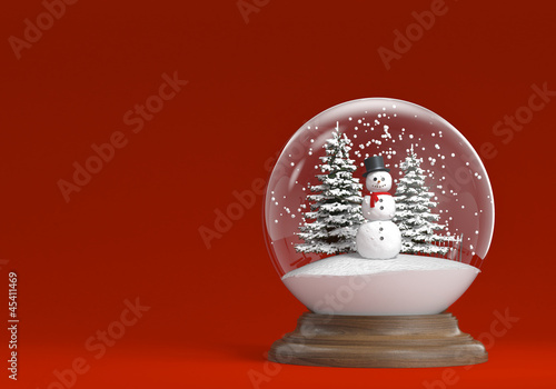 snowglobe with snowman and trees on a red background copy space