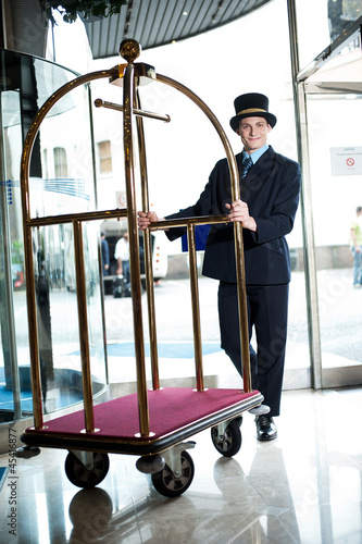 Profile shot of a doorman holding a cart photo