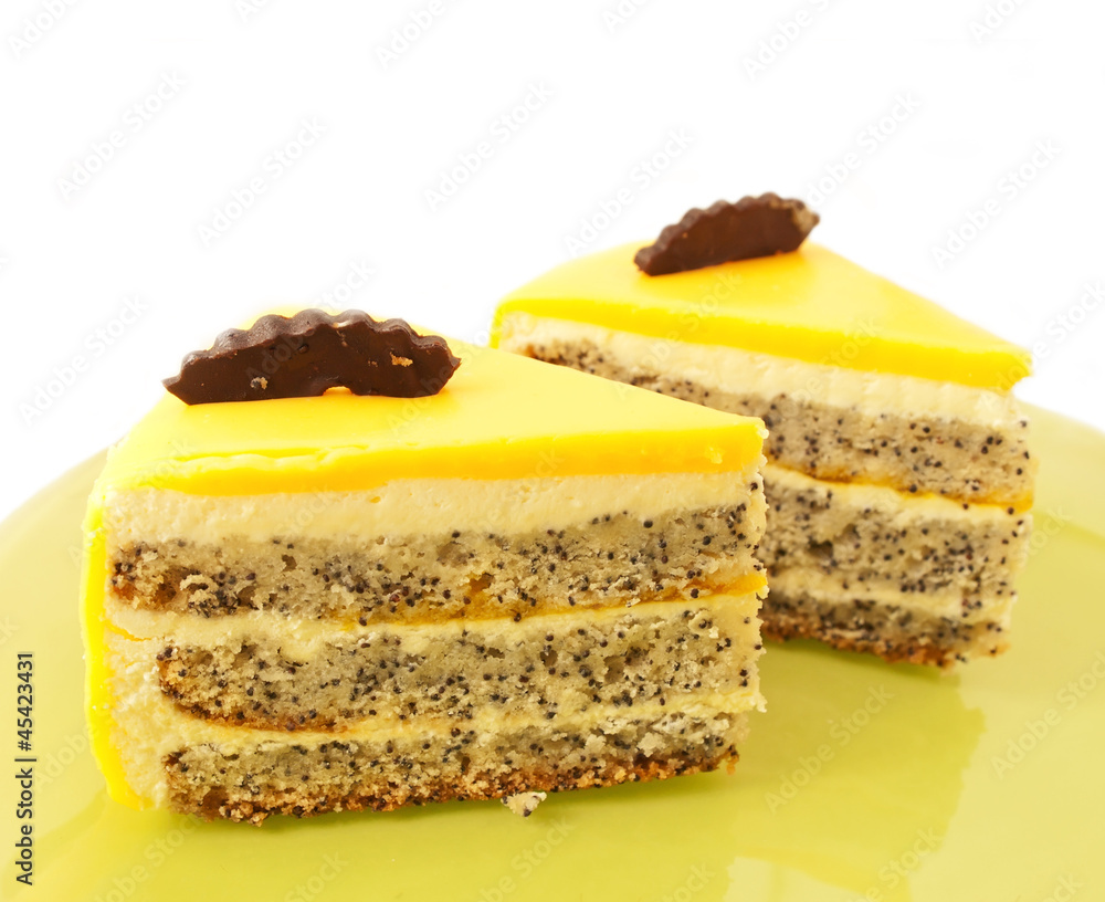 two Slice of delicious mango cake with poppy on green plate two Slice of delicious mango cake with poppy on green plate