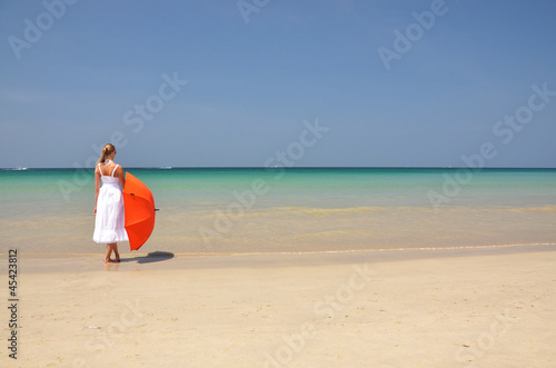 Girl with an orange umbrella on the sandy beach © HappyAlex