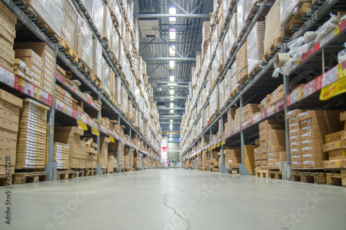 Rows of shelves with boxes in modern warehouse