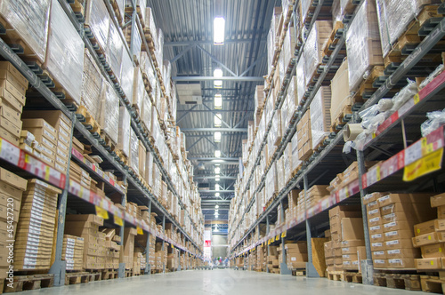 Rows of shelves with boxes in modern warehouse