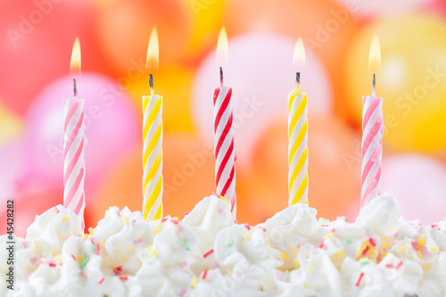 Five Birthday candles on colorful balloons background 