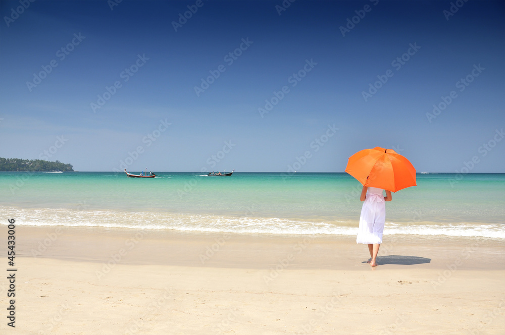 Girl with an orange umbrella on the sandy beach Girl with an orange umbrella on the sandy beach