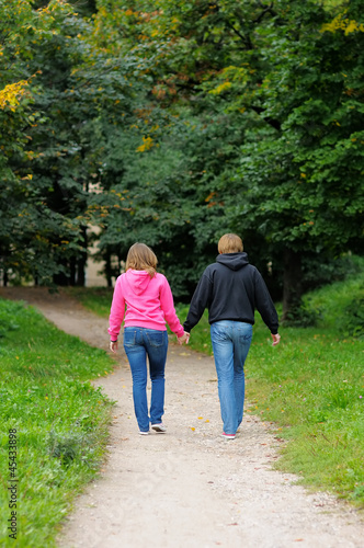 Young couple walking in autumnal park together