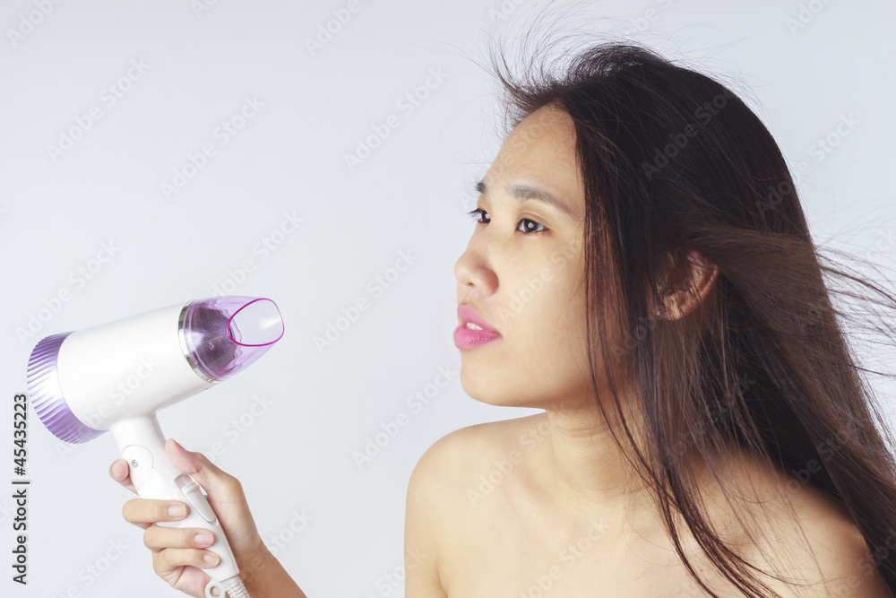 Portrait of beautiful asian woman, she holding hair dryer Portrait of beautiful asian woman, she holding hair dryer