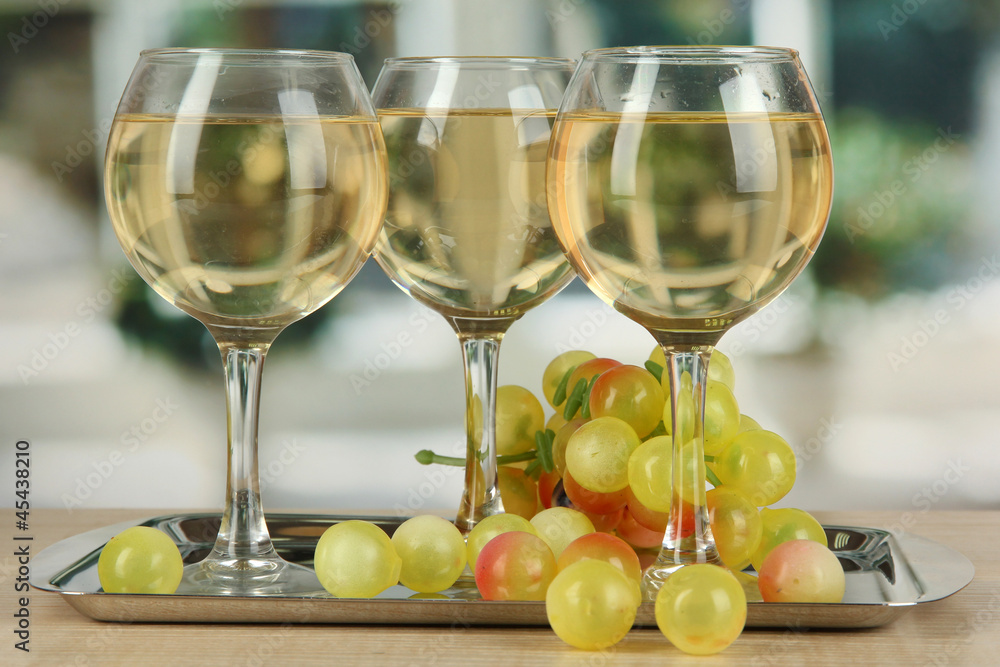 White wine in glass on salver on window background White wine in glass on salver on window background
