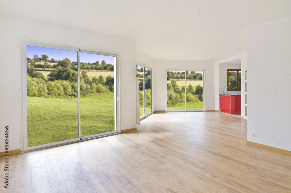 Obraz premium Interieur lumineux de maison ou appartement moderne vide, salon avec parquet, grandes fenêtres avec vue sur la campagne, concept d'achat immobilier ou déménagement