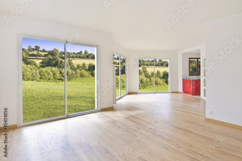 Interieur lumineux de maison ou appartement moderne vide   salon avec parquet  grandes  fen  tres avec vue sur la campagne  concept d achat immobilier ou d  m  nagement