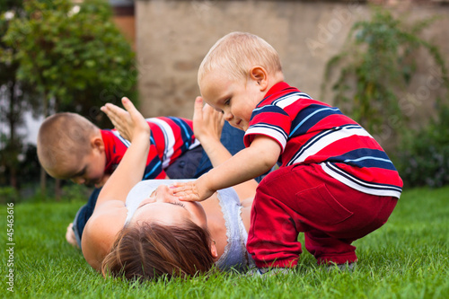 Young woman playing with children outdoors