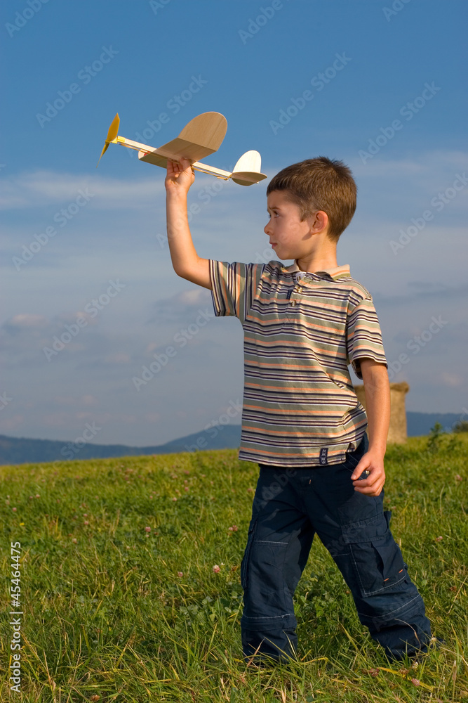 Boy playing with model airplane © Krzysztof Nogawczyk - obrazy, fototapety, plakaty 