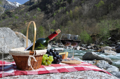 Red wine, cheese and grapes served at a picnic. Verzasca valley,