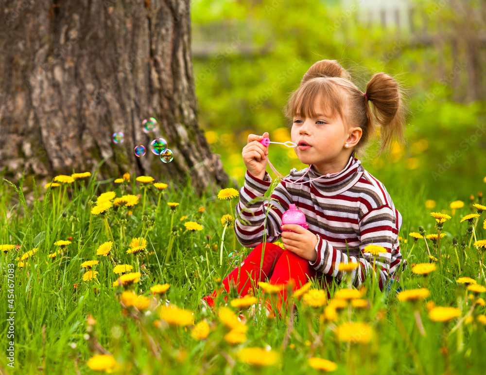 Little five-year girl blowing soap bubbles in the park Little five-year girl blowing soap bubbles in the park