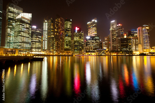 A view of Singapore district in night with water reflections.