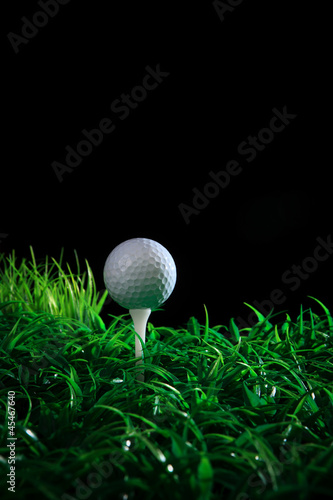 Obraz na płótnie golf ball on green grass with black background