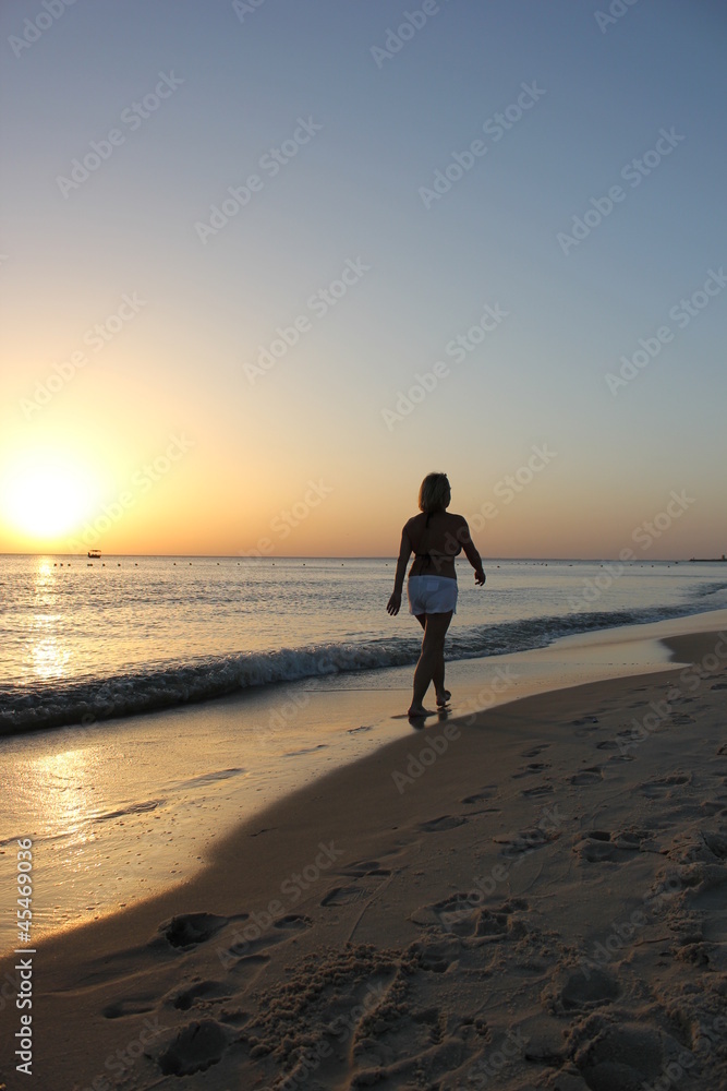 Walking woman in the sunrise
