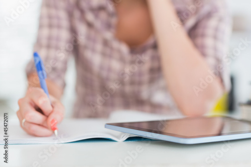 Close up of a woman writing on a notebook