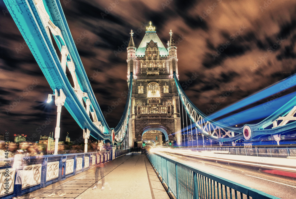Obraz premium Tower Bridge in London, UK at night with traffic and moving red