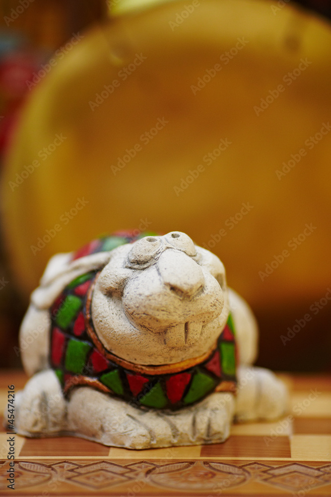 Figurine of chameleon on a chess-board.