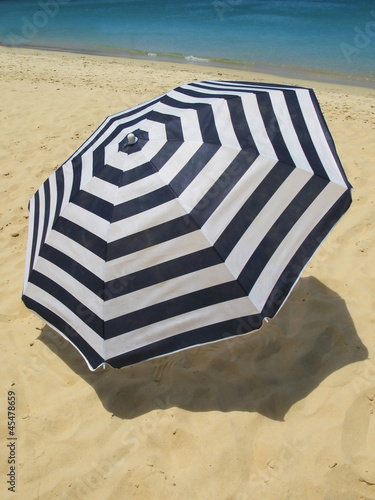 Striped umbrella on a sandy beach