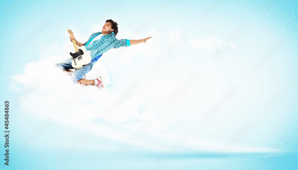 young man playing on electro guitar and jumping young man playing on electro guitar and jumping