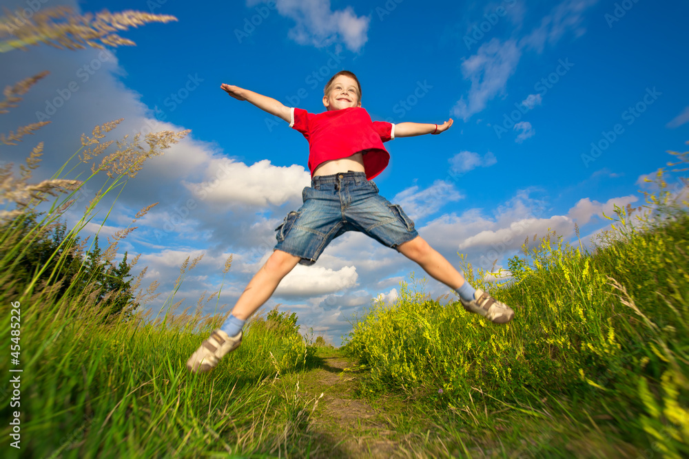 boy jumping against the blue sky boy jumping against the blue sky