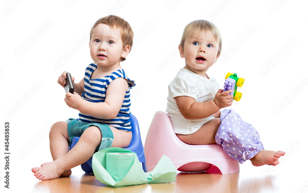 babies toddlers sitting on chamber pot and playing with toys babies toddlers sitting on chamber pot and playing with toys
