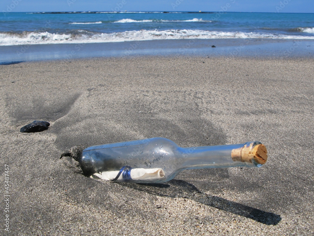 Bottle with a message on the black sand of Tenerife island, Cana Bottle with a message on the black sand of Tenerife island, Cana