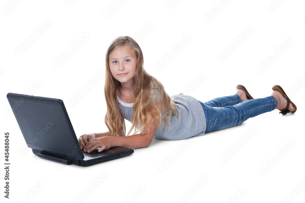 Little Girl Lying On Floor Using A Laptop Little Girl Lying On Floor Using A Laptop