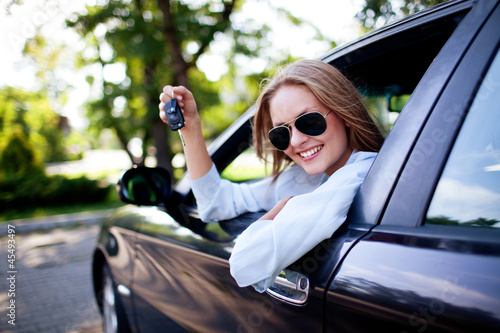 Young woman shows the keys to her new car photo