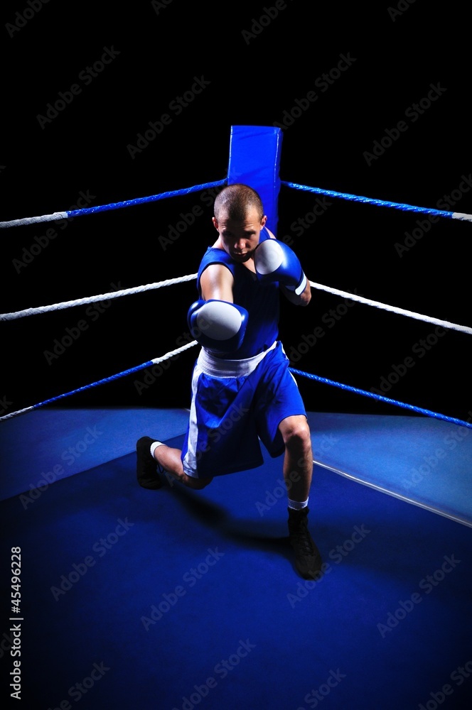 Fototapeta premium Male boxer in ring doing exercise