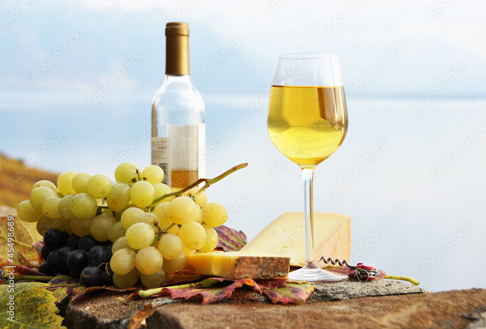 Wineglass, cheese and grapes on the terrace of vineyard in Lavau