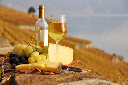 Wineglass and a bottle on the terrace vineyard in Lavaux region,