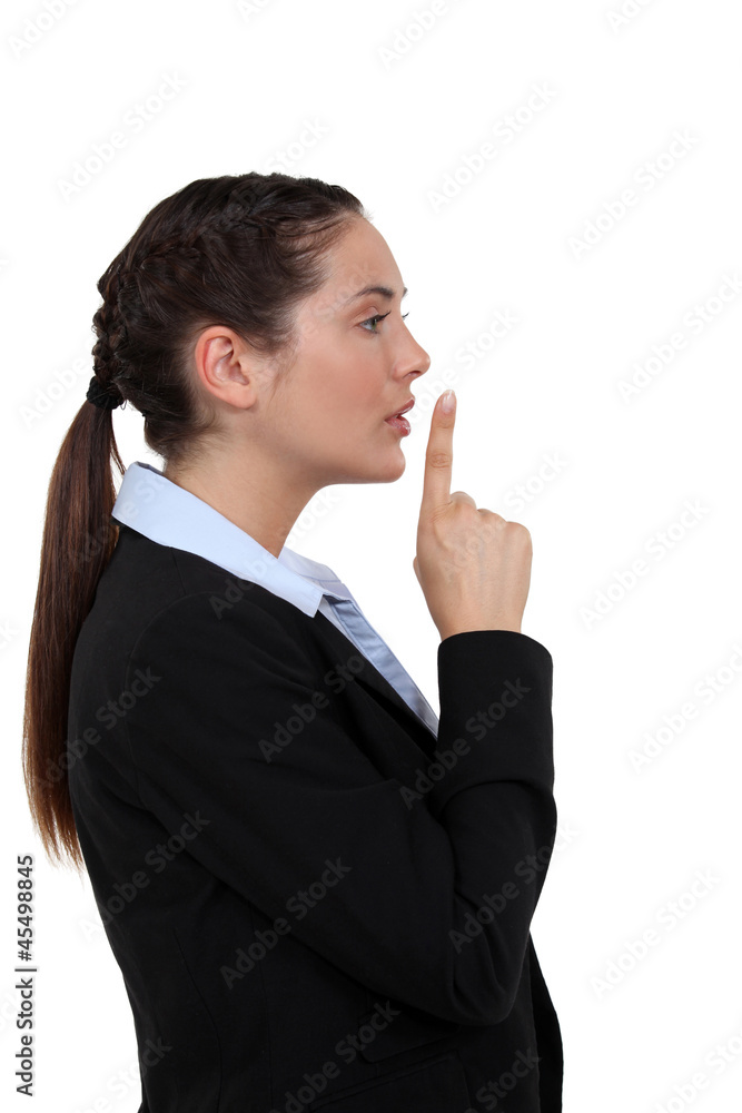 Woman holding her index finger to her lips Woman holding her index finger to her lips