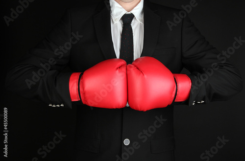 businessman in boxing gloves isolated on black © Africa Studio