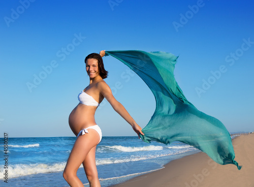 Cuadro en lienzo Beautiful pregnant woman walking on blue beach
