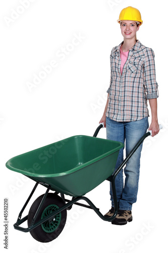 Obraz na płótnie craftswoman pushing a wheelbarrow