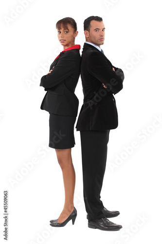 Businessman and businesswoman standing back-to-back