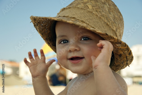 Baby with hat on the beach