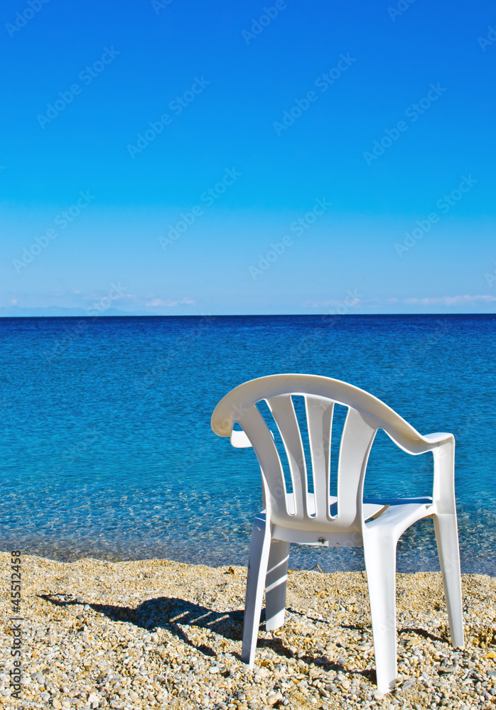 plastic beach chair on shore near sea